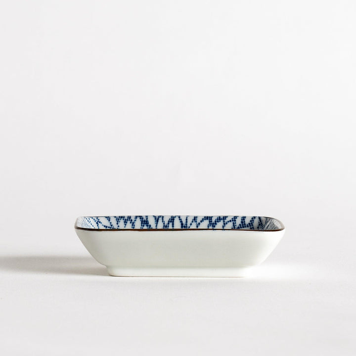 A small rectangular dish featuring a blue herringbone pattern on a white background.