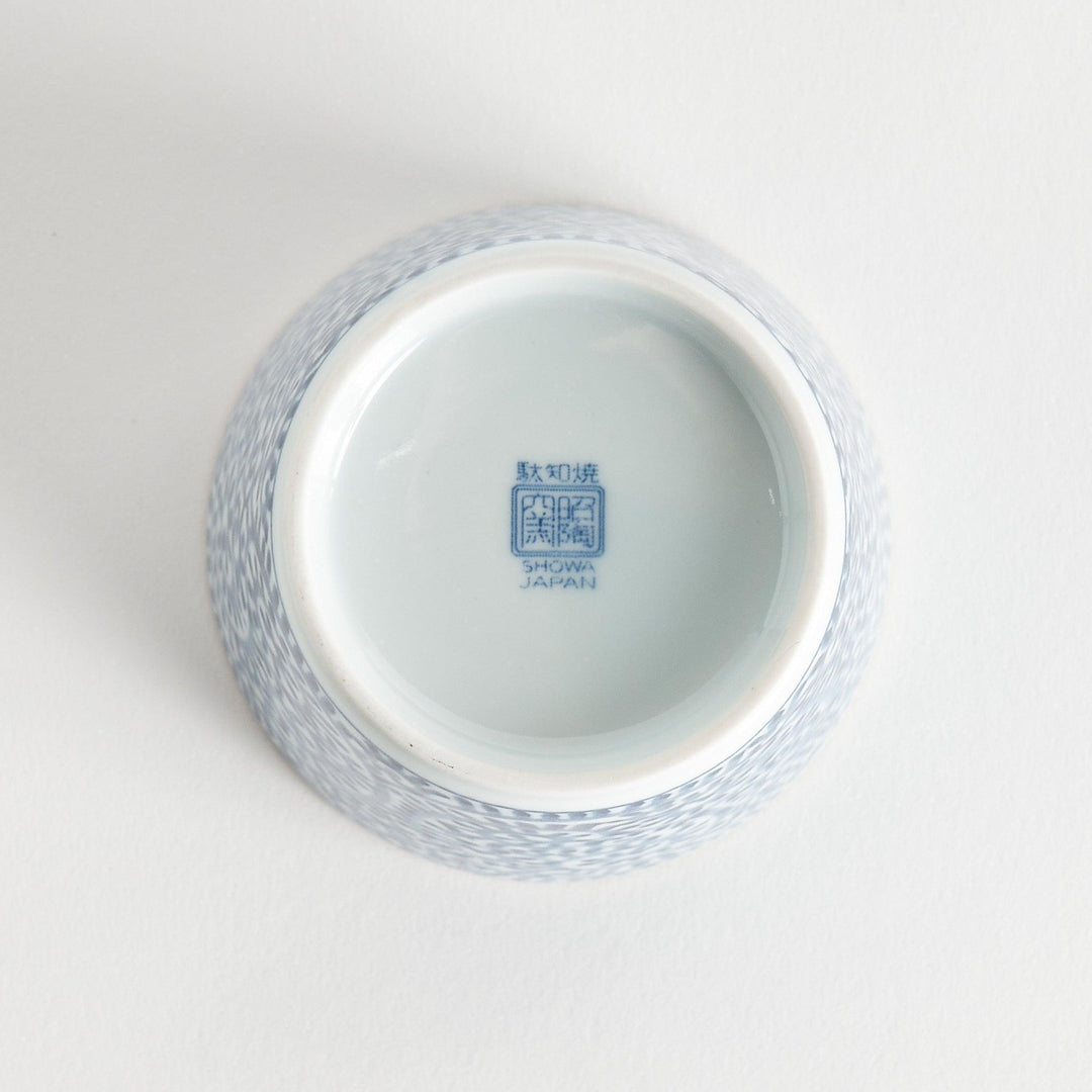 A small cylindrical cup featuring a detailed blue spiral pattern on a white base.