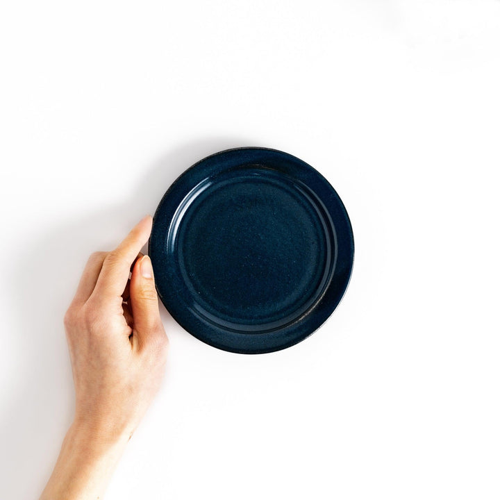 Hand-held blue ceramic dessert plate showcasing its sleek glossy surface and compact size, ideal for everyday dining or special occasions.