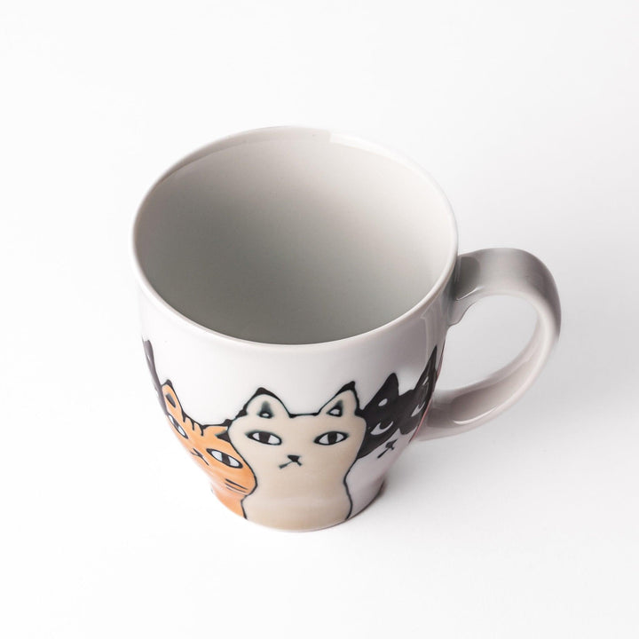Whimsical cat mug featuring a line-up of curious cats in various colors, including orange, blue, and black, adding a playful touch to your coffee or tea time.