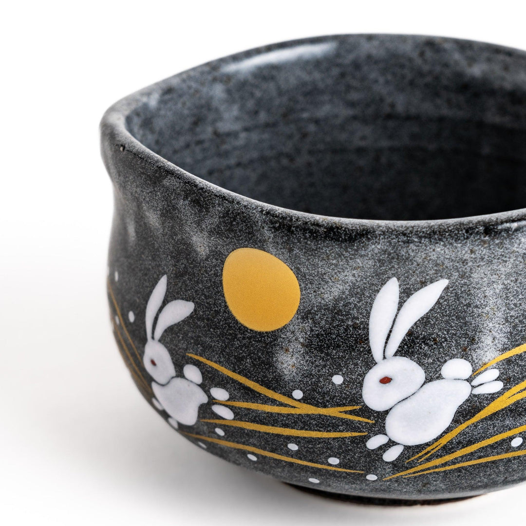 Gray matcha bowl with a charming design of rabbits hopping under a full moon, perfect for preparing and enjoying traditional matcha tea.
