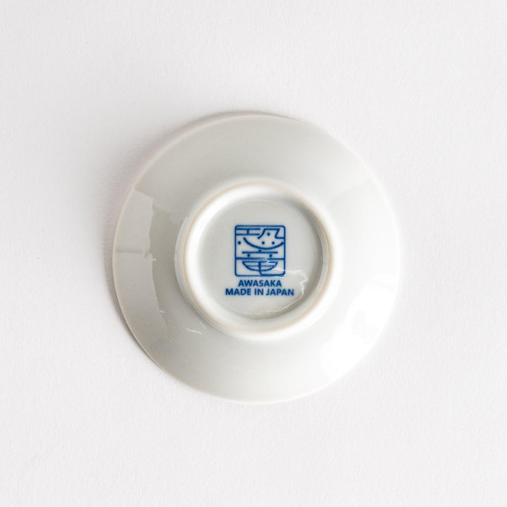 A set of four small, decorative porcelain plates in a gift box, each plate featuring a different dinosaur design in blue and red.