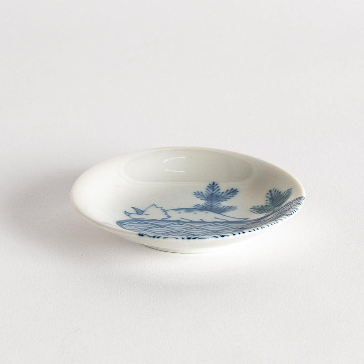 A set of four small, decorative porcelain plates in a gift box, each plate featuring a different dinosaur design in blue and red.