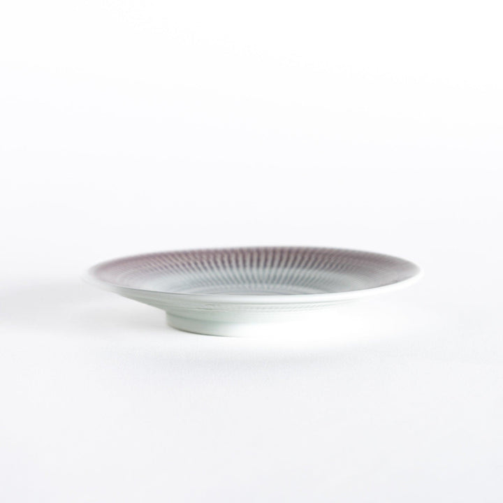 Side view of the light purple dessert plate, highlighting its smooth curve and clean edges.