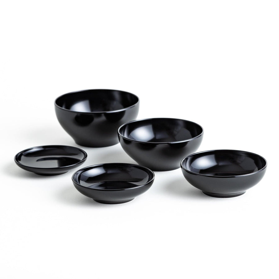 Set of five nested lacquer bowls used in Japanese oryoki meals representing minimalism mindfulness in black or red.