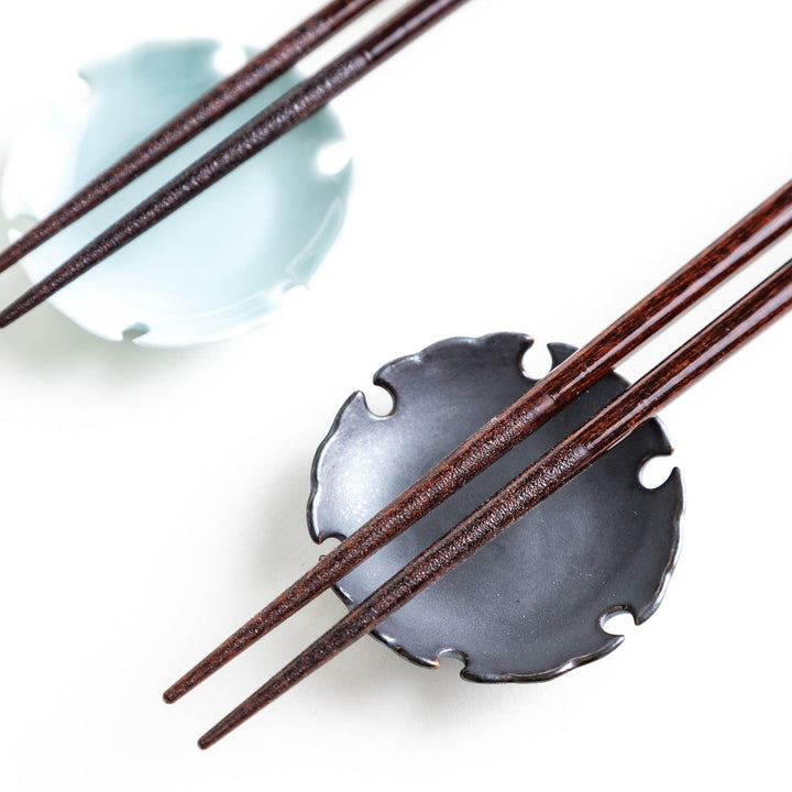 A pair of chopsticks with a sleek design featuring glitter accents and small floral patterns in deep red and navy blue, adding a touch of sparkle to your dining experience.