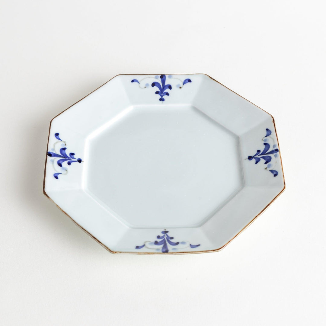 Octagonal white porcelain salad plate with a blue floral motif and brown accent trim.
