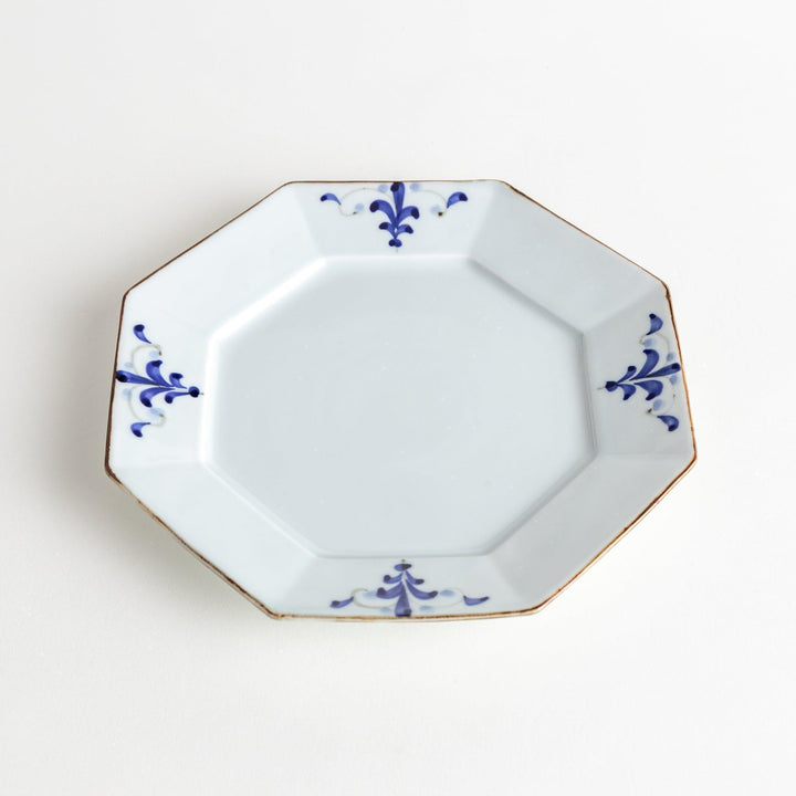 Octagonal white porcelain salad plate with a blue floral motif and brown accent trim.