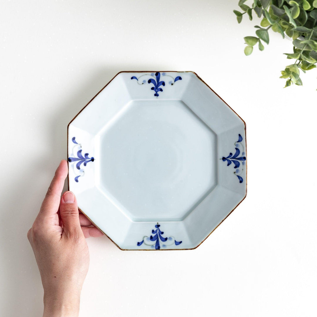 Octagonal white porcelain salad plate with a blue floral motif and brown accent trim.