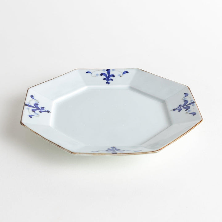 Octagonal white porcelain salad plate with a blue floral motif and brown accent trim.