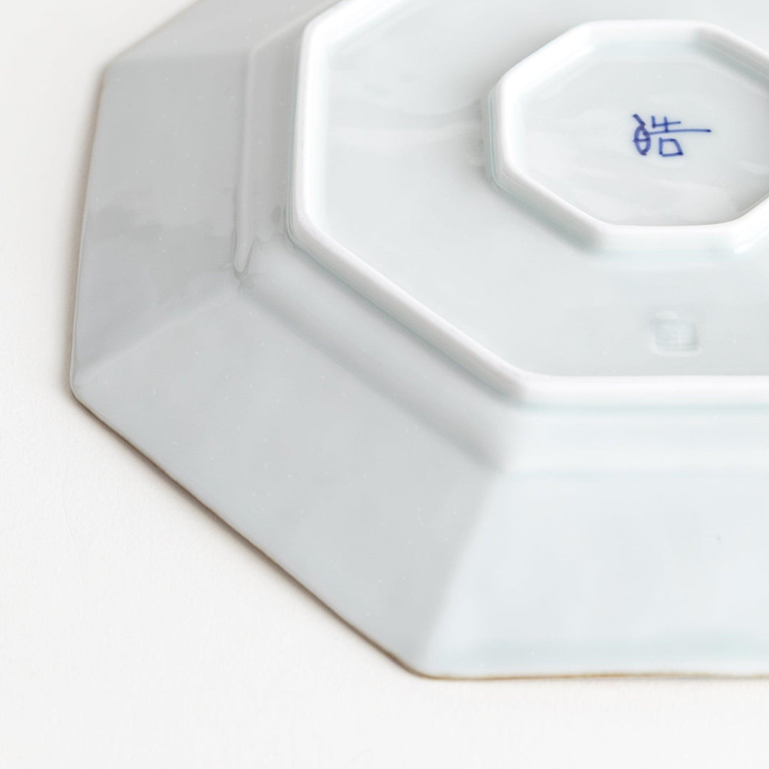 Octagonal white porcelain salad plate with a blue floral motif and brown accent trim.