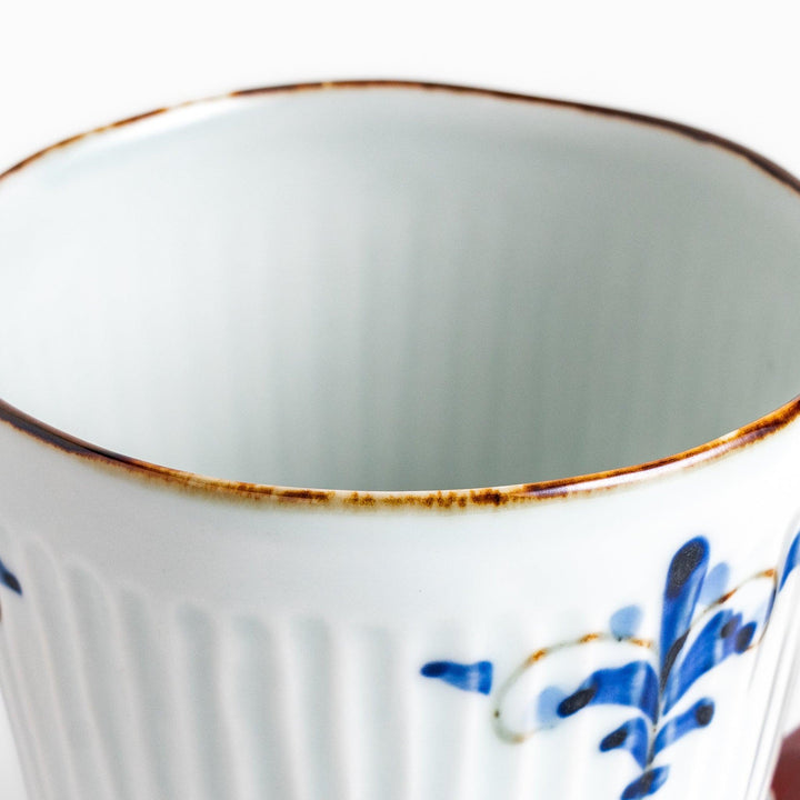 Charming floral leaves mug with intricate blue floral patterns, complemented by a red handle and gold trim, adding a touch of elegance to your tea time.