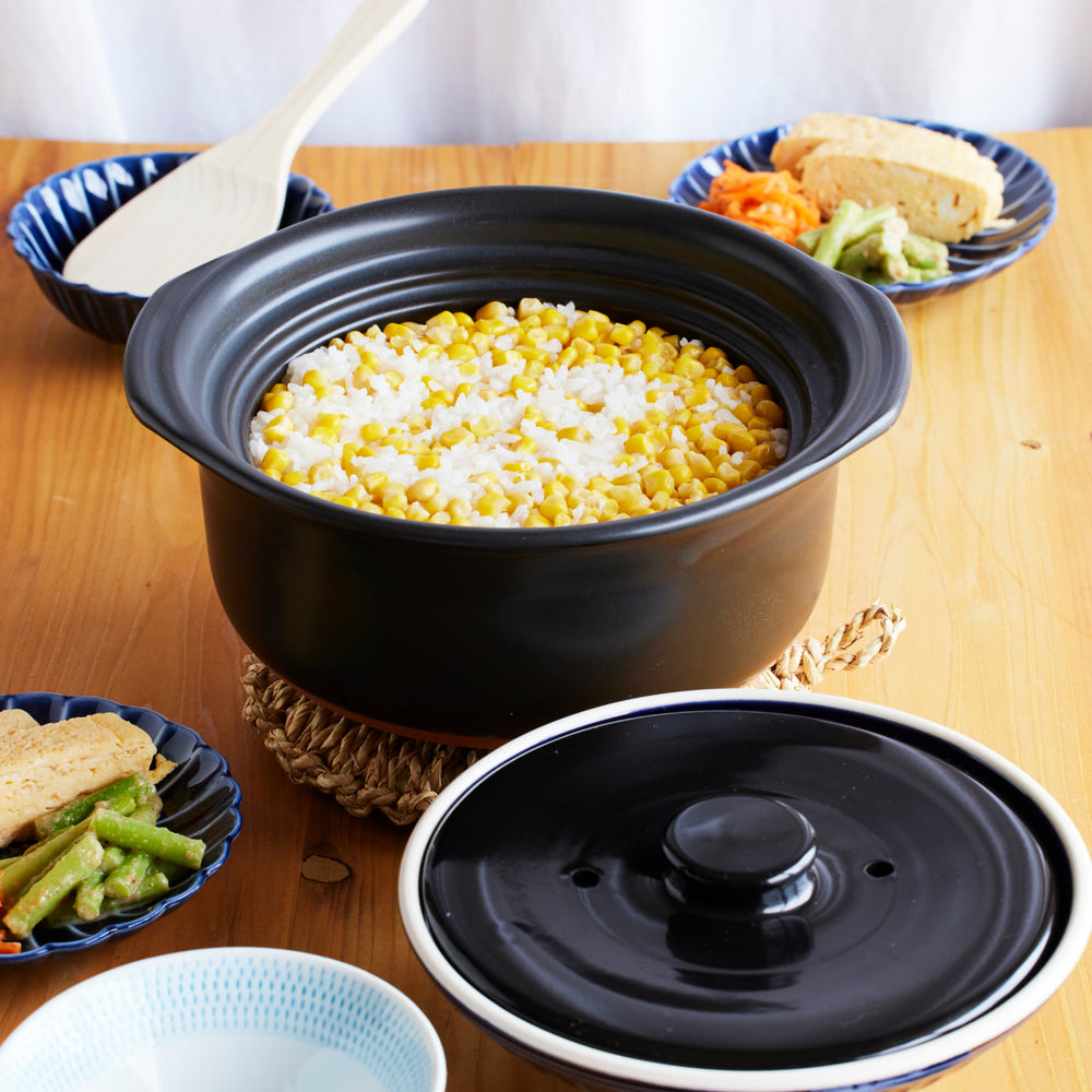 Ginpo Kikka Lapis rice donabe, handcrafted in Japan, shown with lid removed to reveal freshly cooked corn rice for everyday family dining.