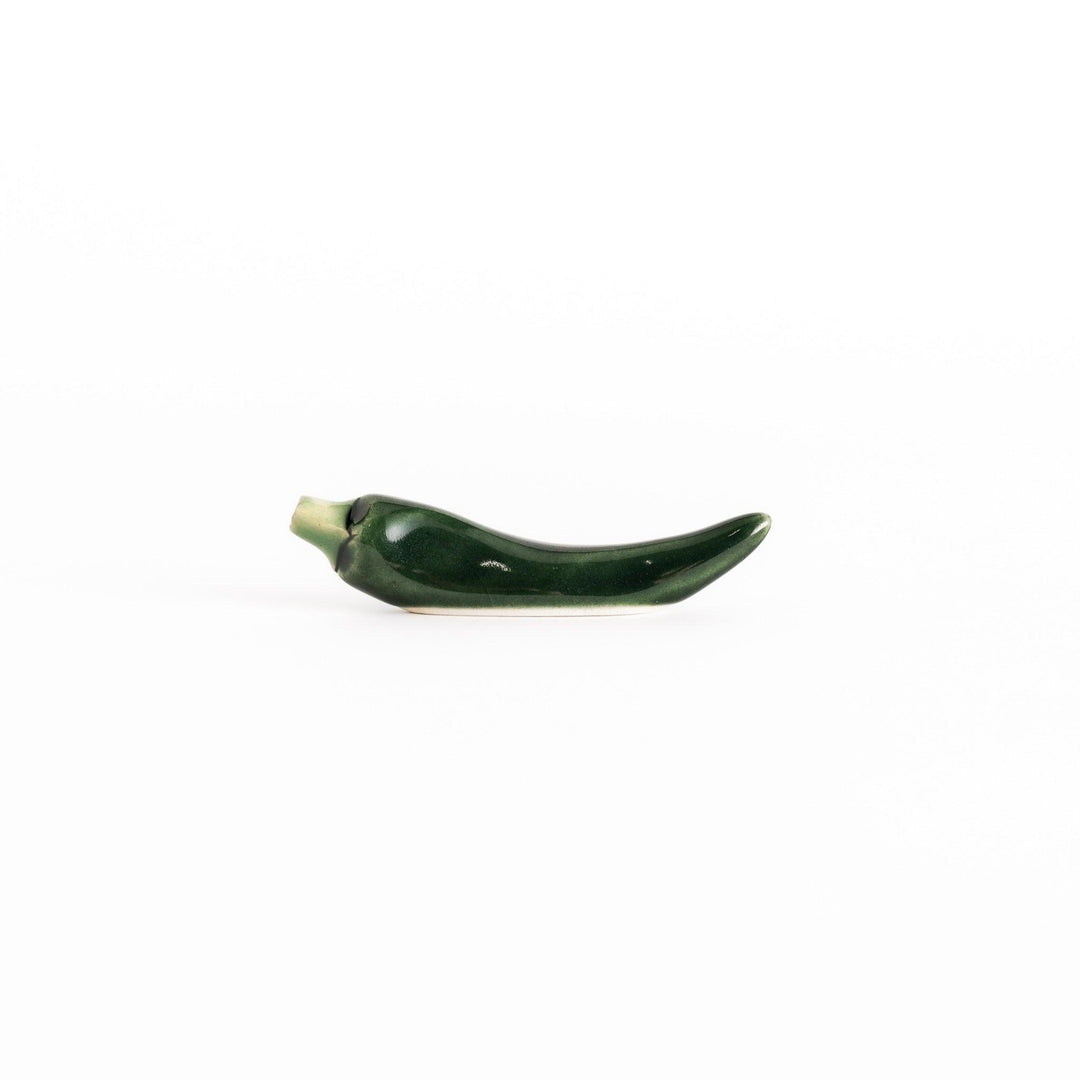 Side view of the green chili pepper chopsticks rest, capturing its curved design and vibrant green color.