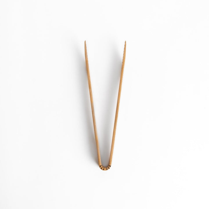 Elegant handcrafted wooden tongs with a smooth finish and angled tips, perfect for serving and handling food in a stylish way.