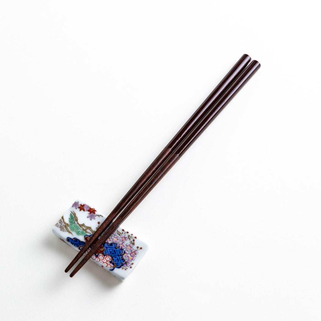 Chopsticks in different colors—white, yellow, olive green, navy blue, and dark brown—with wooden lower halves.