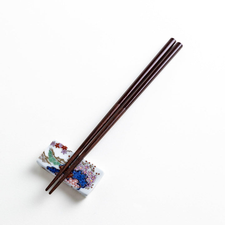 Chopsticks in different colors—white, yellow, olive green, navy blue, and dark brown—with wooden lower halves.
