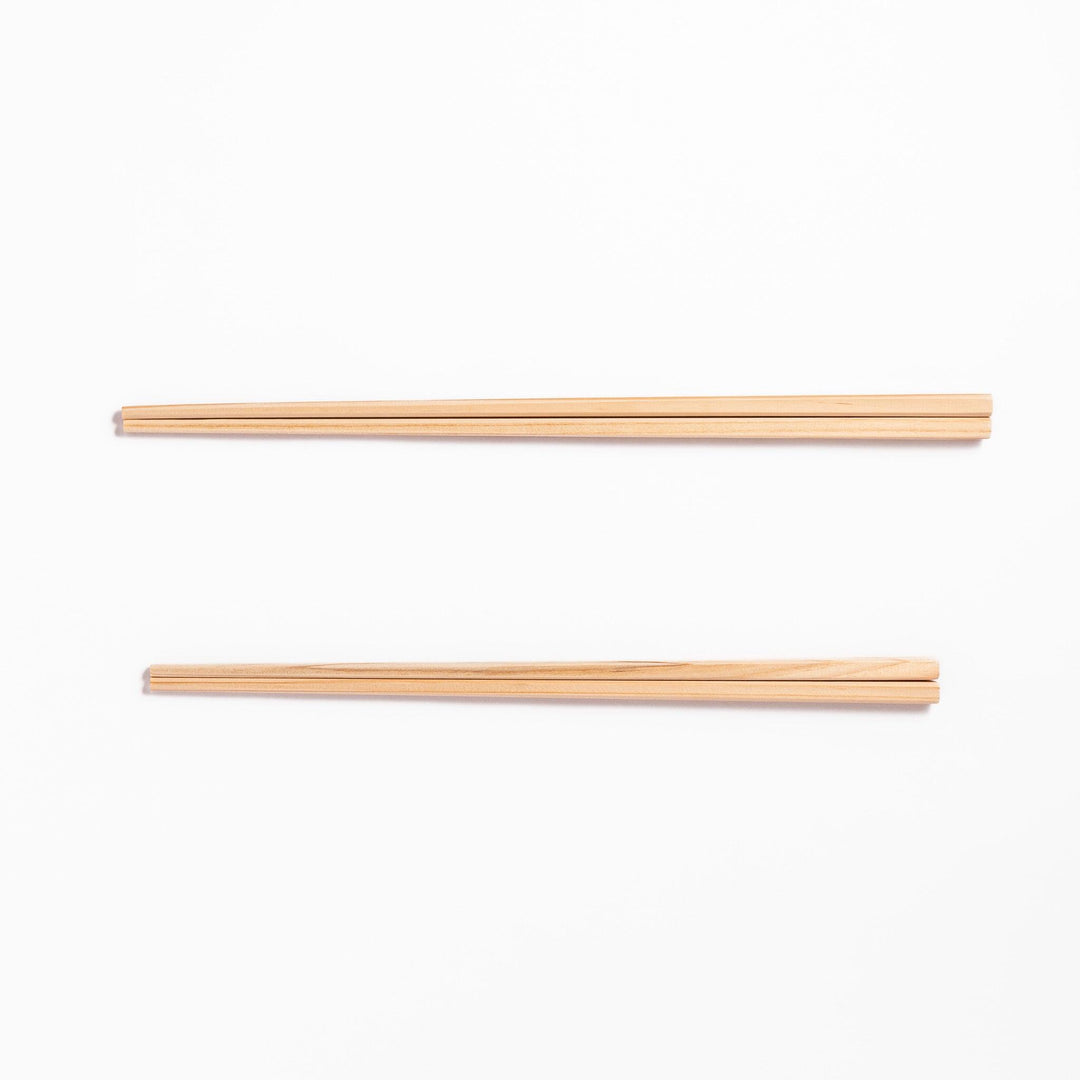 Pair of hinoki wood cooking chopsticks with smooth light wood grain and tapered ends, ideal for Japanese cuisine