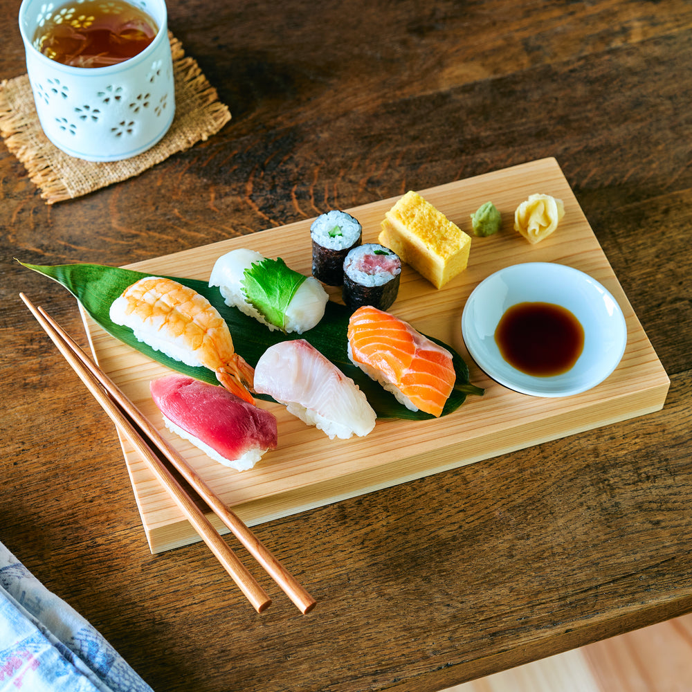 Hinoki wood sushi plate set with assorted nigiri, soy sauce dish, and chopsticks, showcasing clean grain and ideal for Japanese food presentation.