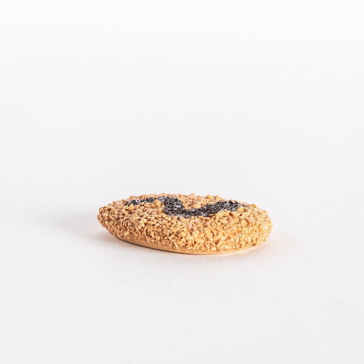 Side view of a Japanese croquette-shaped chopstick rest, showing its round shape, textured coating, and black swirl marking.


