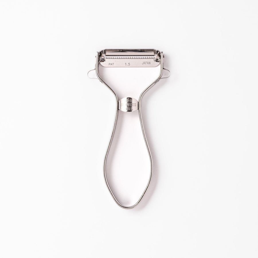 Japanese daikon julienne peeler with stainless steel blade and ergonomic looped handle for thin vegetable strips