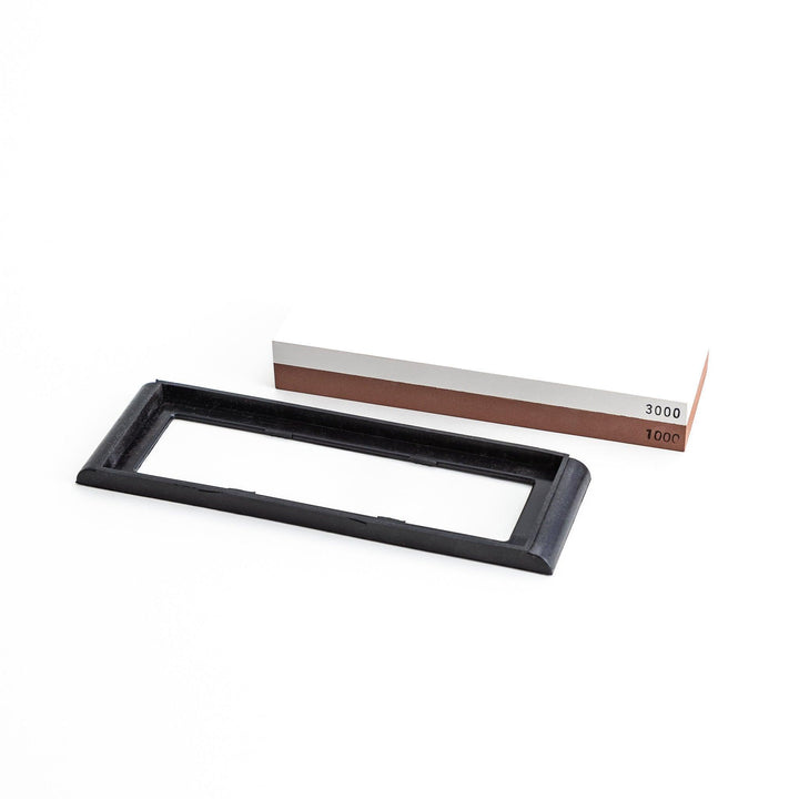 Rectangular sharpening stone with a brown surface and a black base, designed for honing knife blades.