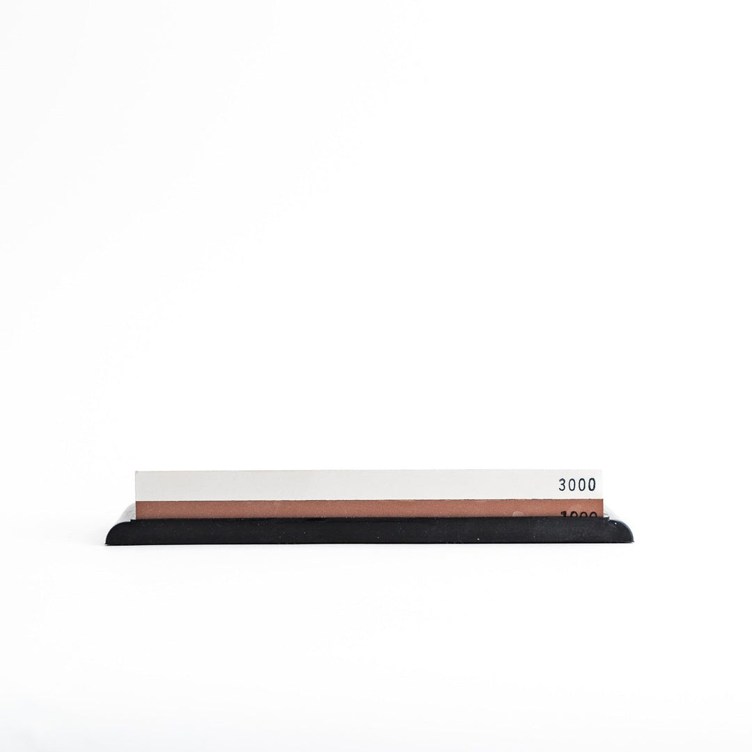Rectangular sharpening stone with a brown surface and a black base, designed for honing knife blades.