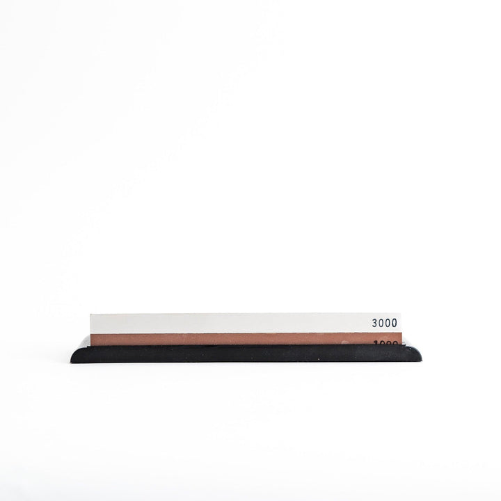Rectangular sharpening stone with a brown surface and a black base, designed for honing knife blades.
