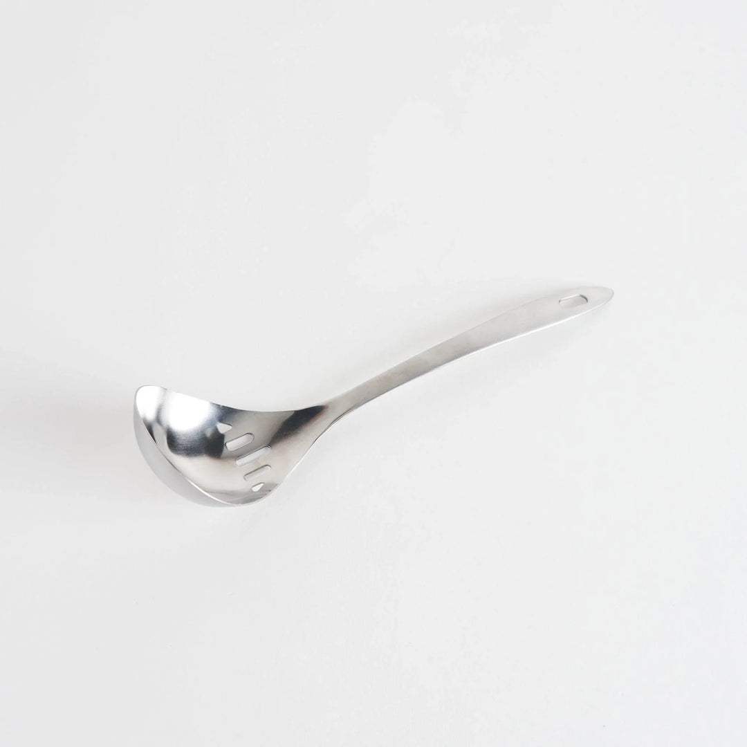 A stainless steel ladle with small drainage holes and a wide, deep scoop, designed for straining while serving.