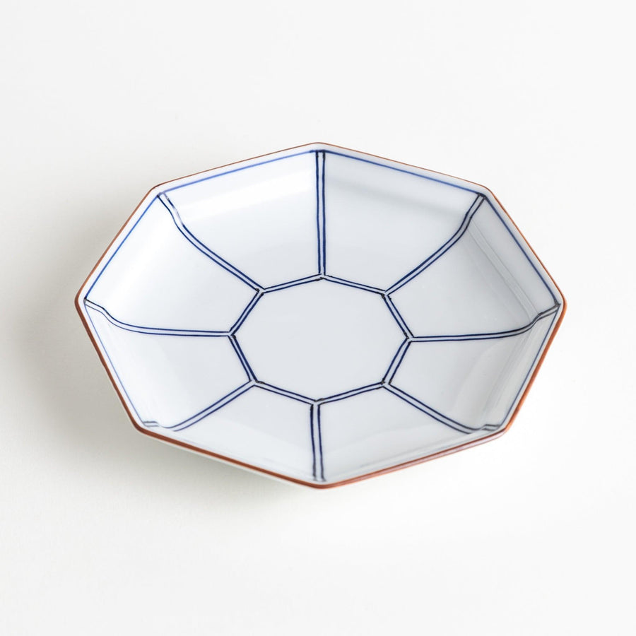 An octagonal porcelain dessert plate with a minimalist grid pattern.