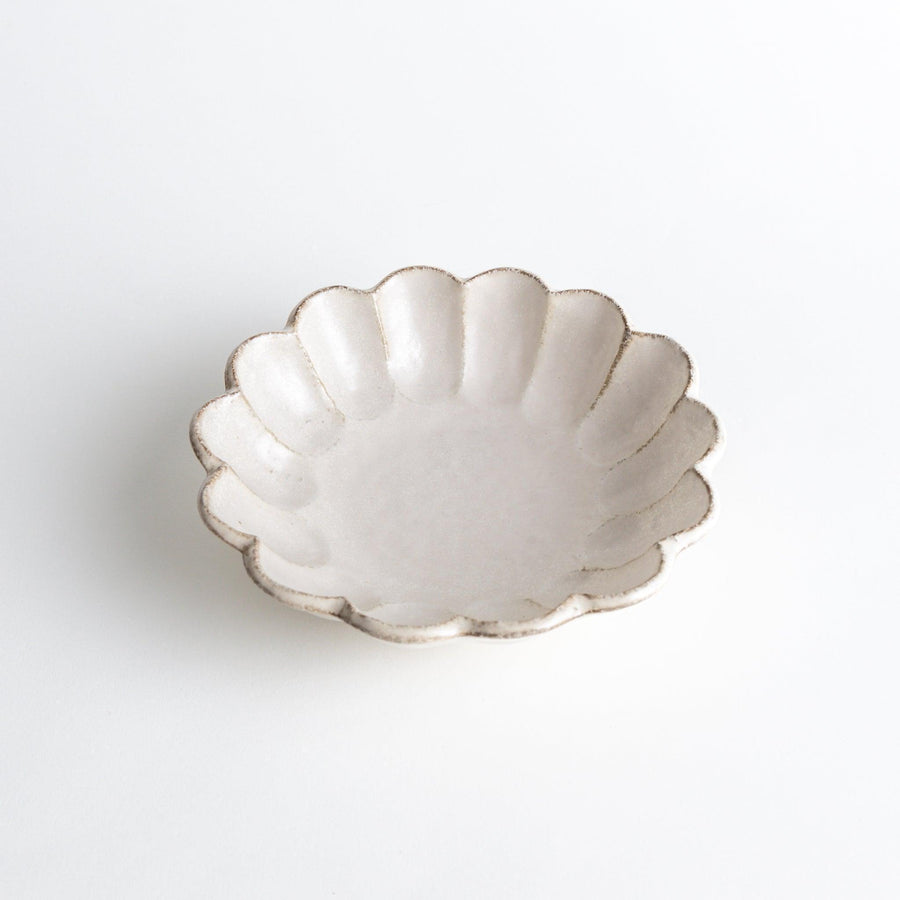 A white ceramic pasta bowl with a scalloped flower-petal design.