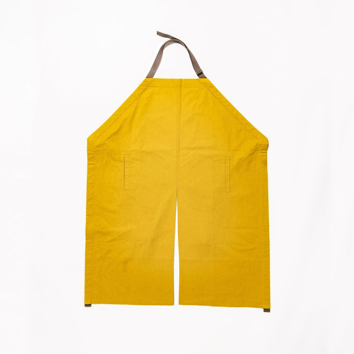 Stylish mustard yellow Japanese apron from our kitchen linens collection, featuring pockets and adjustable straps.