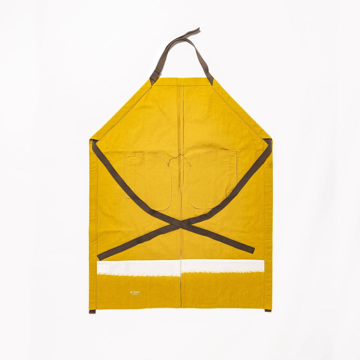 Stylish mustard yellow Japanese apron from our kitchen linens collection, featuring pockets and adjustable straps.