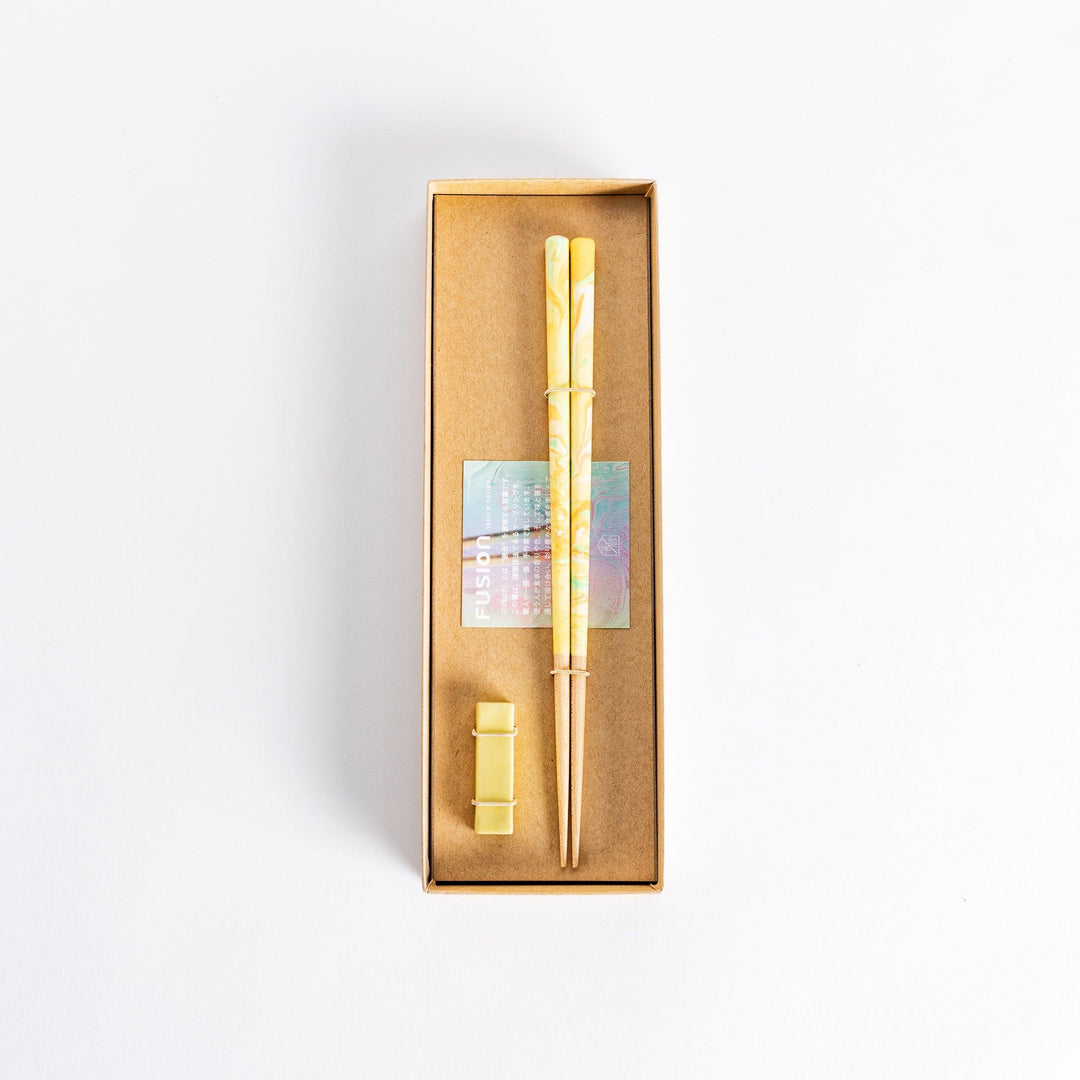 Colorful marbled chopsticks with hues of yellow, green, and orange, creating a vibrant fusion design. Paired with a matching rest.