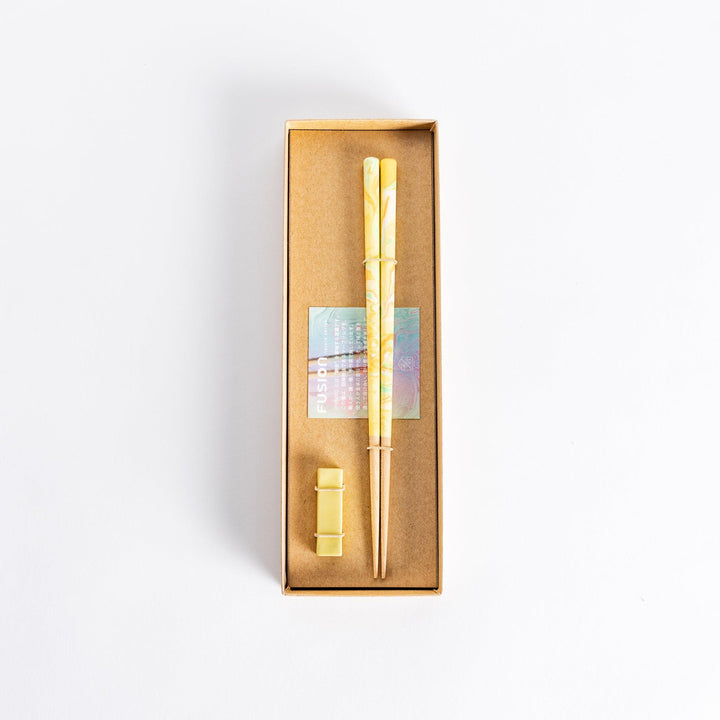 Colorful marbled chopsticks with hues of yellow, green, and orange, creating a vibrant fusion design. Paired with a matching rest.