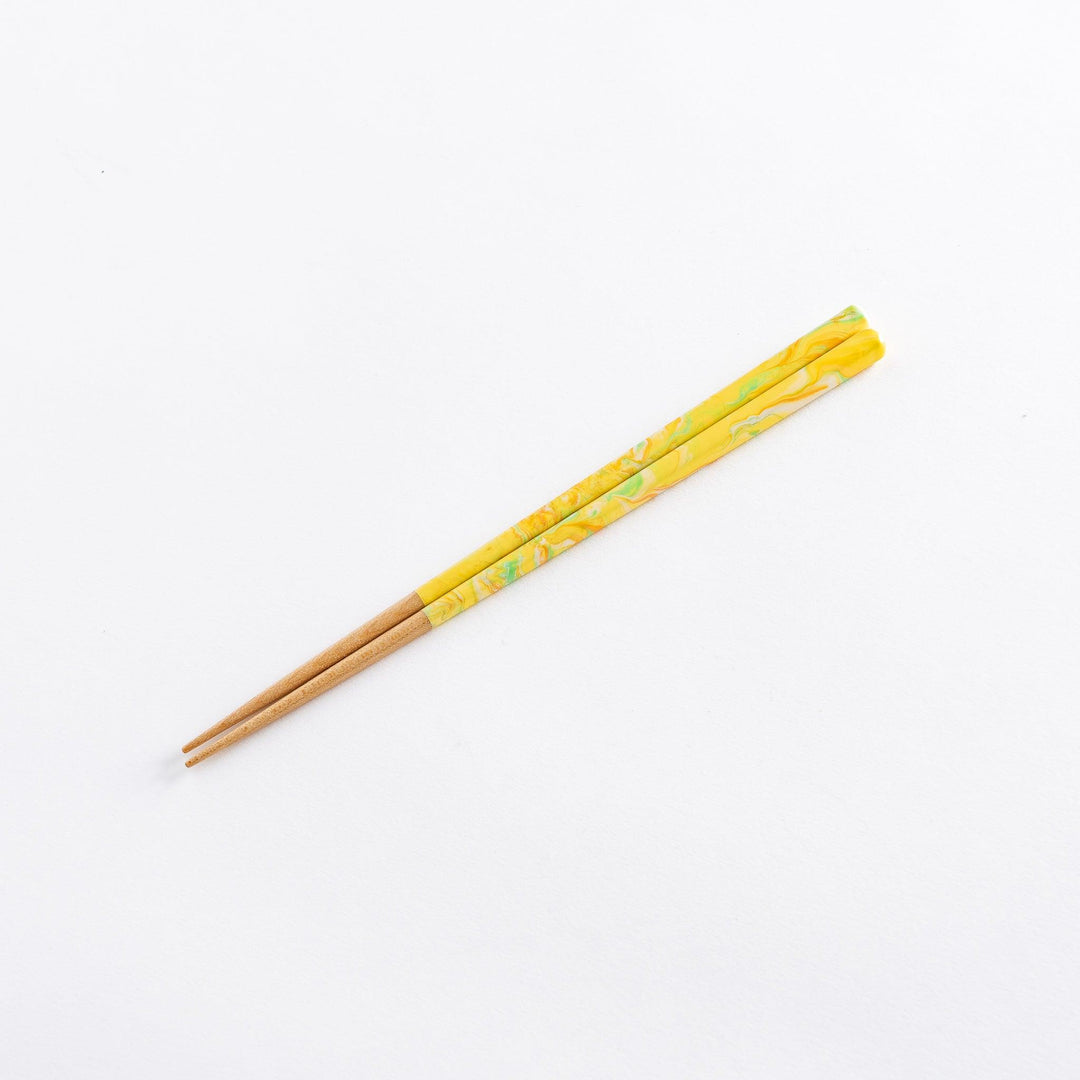 Chopsticks featuring marbled yellow, orange, and green tips with wooden shafts. A vibrant and stylish addition to any dining experience.