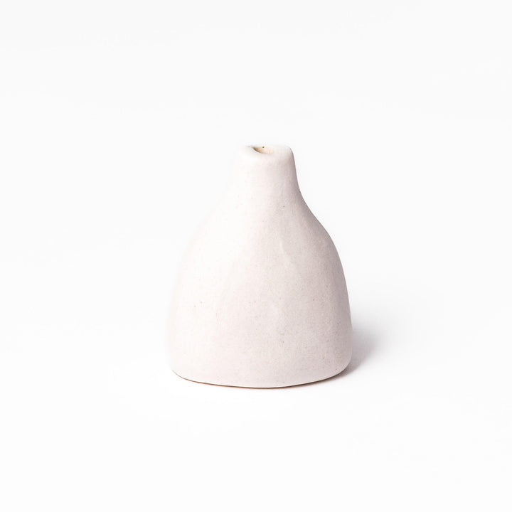 Minimalist white ceramic bud vase with a teardrop shape and narrow opening, ideal for showcasing a single flower in a serene, modern setting.