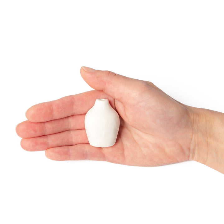 Minimalist white ceramic bud vase with a pear-shaped silhouette and narrow opening, perfect for displaying a single flower or small arrangement.