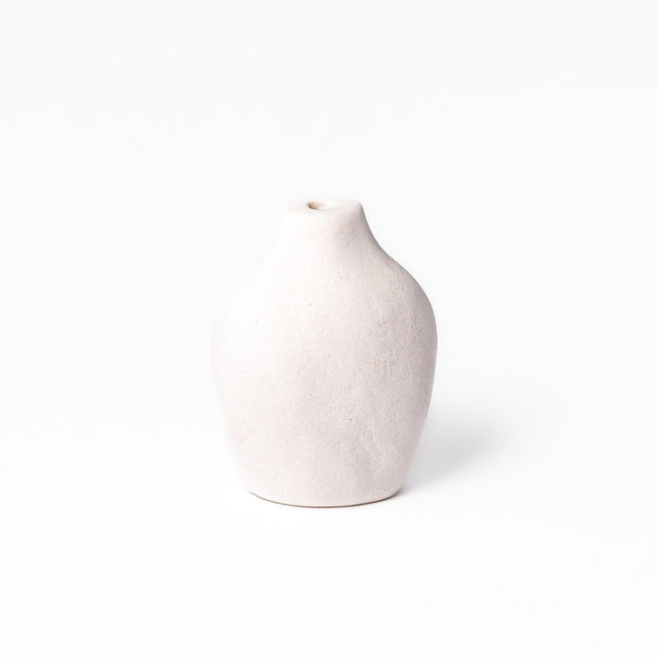Minimalist white ceramic bud vase with a pear-shaped silhouette and narrow opening, perfect for displaying a single flower or small arrangement.