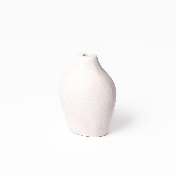Minimalist white ceramic bud vase with a pear-shaped silhouette and narrow opening, perfect for displaying a single flower or small arrangement.