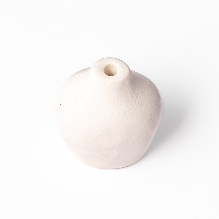 Minimalist white ceramic bud vase with a pear-shaped silhouette and narrow opening, perfect for displaying a single flower or small arrangement.