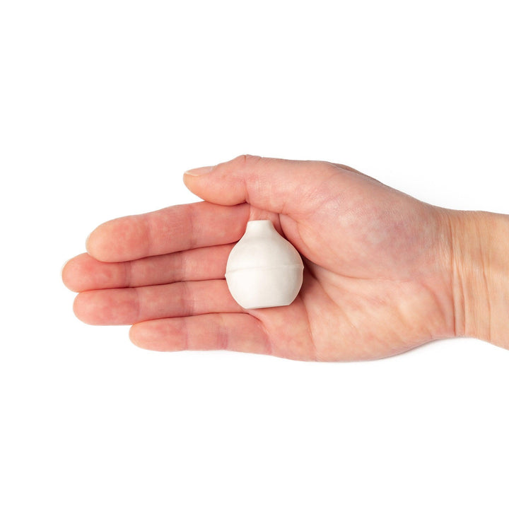 Minimalist white ceramic bud vase with an orb-like shape and subtle center ridge, ideal for adding soft, sculptural charm to any small floral display.