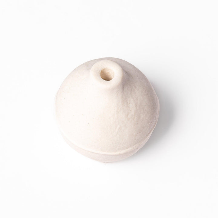 Minimalist white ceramic bud vase with an orb-like shape and subtle center ridge, ideal for adding soft, sculptural charm to any small floral display.