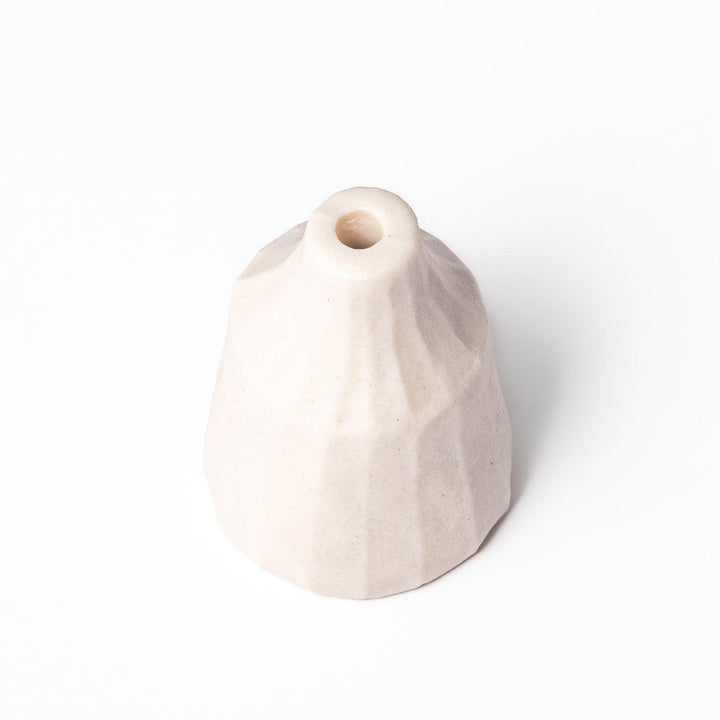 Minimalist white ceramic bud vase with a faceted prism shape and narrow neck, offering a modern geometric touch for single stems or dried flowers.