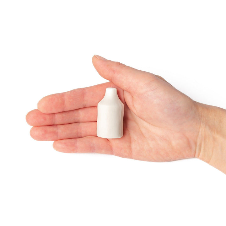 Minimalist white ceramic bud vase with a cylindrical body and narrow neck, perfect for single stems and adding clean, modern charm to any space.