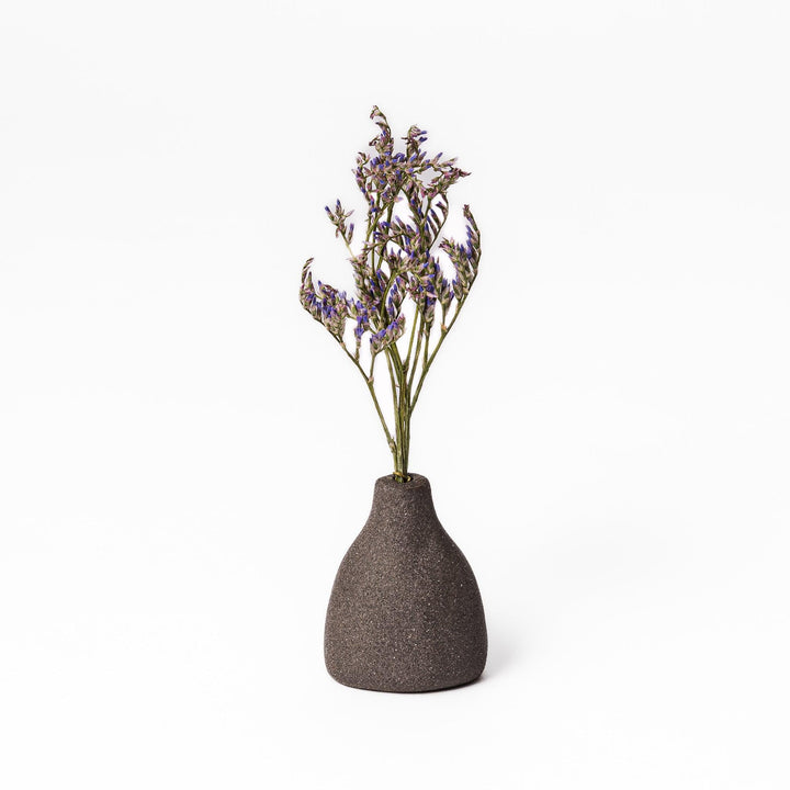 Minimalist dark ceramic bud vase with a teardrop silhouette and textured surface, perfect for adding earthy elegance to floral or dried arrangements.