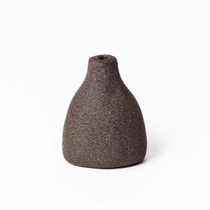 Minimalist dark ceramic bud vase with a teardrop silhouette and textured surface, perfect for adding earthy elegance to floral or dried arrangements.