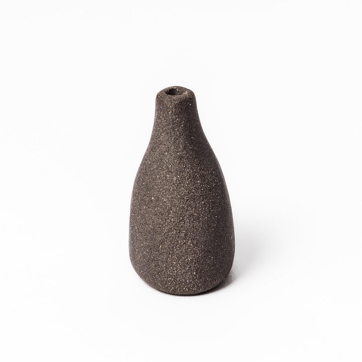 Minimalist dark ceramic bud vase with a teardrop silhouette and textured surface, perfect for adding earthy elegance to floral or dried arrangements.