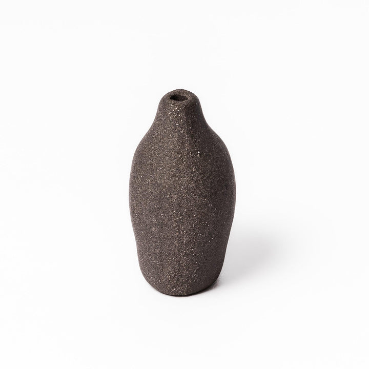 Minimalist dark ceramic bud vase with a pear-shaped form and textured finish, ideal for adding warmth and organic charm to floral displays.