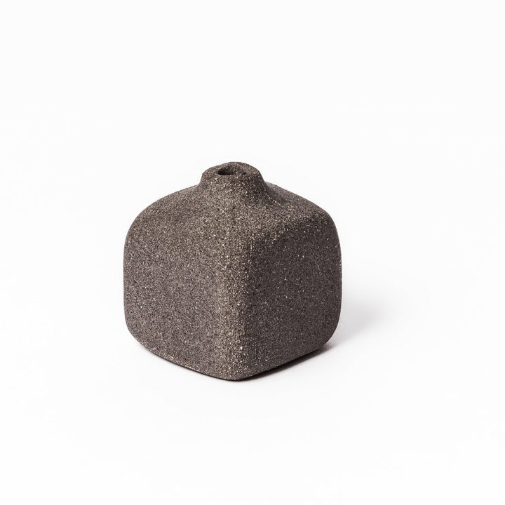 Minimalist dark ceramic bud vase with a square body and soft rounded edges, offering a modern, textured design perfect for small floral accents.
